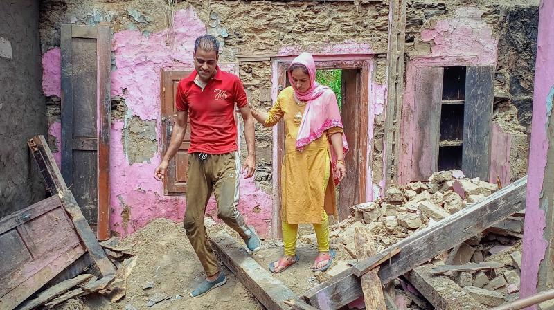 Bhaderwah: 7-month pregnant Nishu walks through the rubble of her mud house, in Bhaderwah. (PTI Photo) Bhaderwah: 7-month pregnant Nishu walks through the rubble of her mud house, in Bhaderwah. (PTI Photo)
