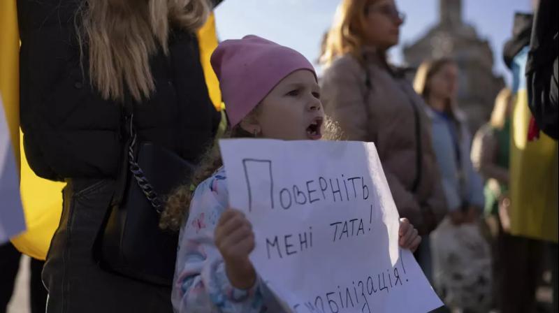 Russia-Ukraine war : A girl holds a poster reading, “Bring my father back. Demobilization!” during a rally in Independence Square in Kyiv, Ukraine, on Friday.