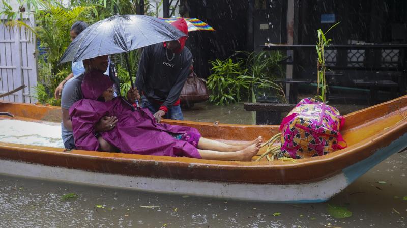 Chennai: Residents shift to a safer place from a flooded area during heavy rain owing to Cyclone Michaung, in Chennai, Monday, Dec. 4, 2023. (PTI Photo)