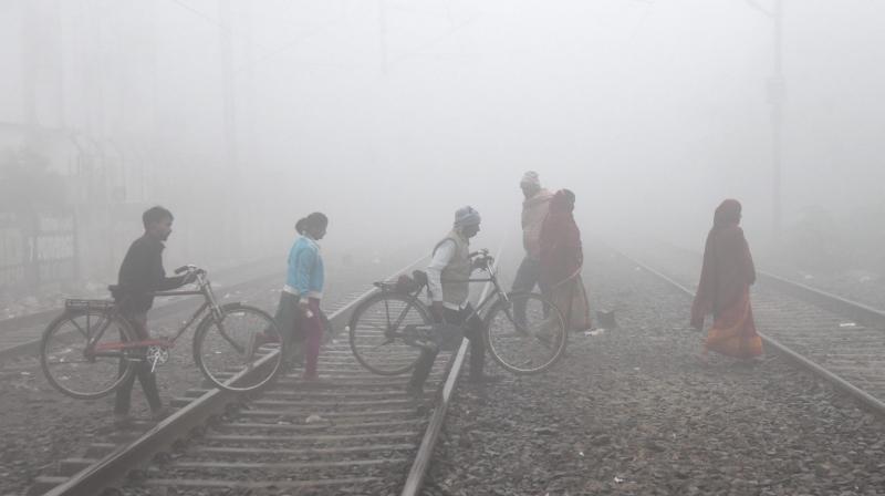 Patna: Commuters cross railway tracks amid fog on a cold winter morning, in Patna, Friday, Dec. 29, 2023. (PTI Photo) Patna: Commuters cross railway tracks amid fog on a cold winter morning, in Patna, Friday, Dec. 29, 2023. (PTI Photo)