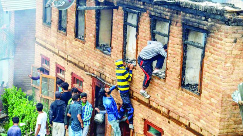 Looking under the building where terrorists were hiding, Kashmiri youth Looking under the building where terrorists were hiding, Kashmiri youth