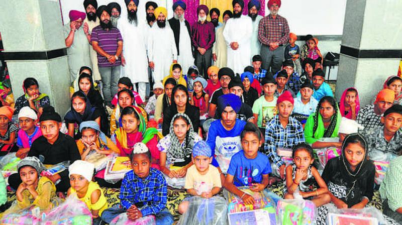Children, who received study material, with their parents in Jammu.