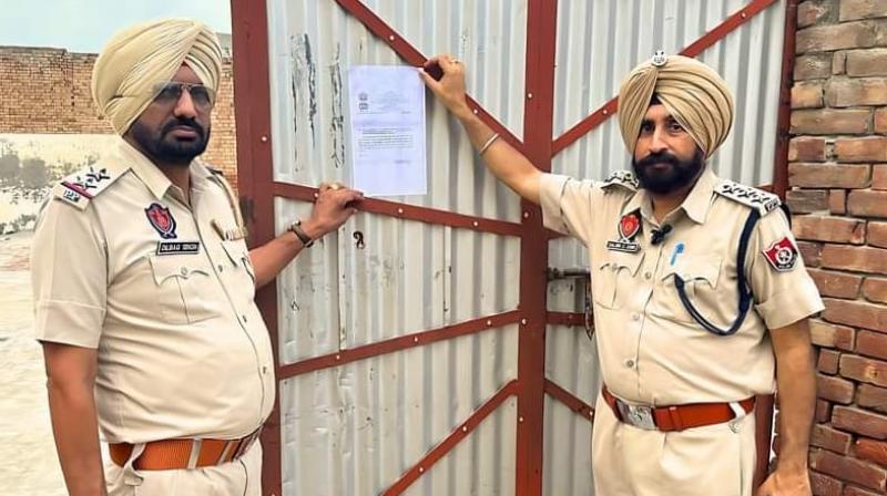 ਪੁਲਿਸ ਨਸ਼ਾ ਤਸਕਰ ਦੇ ਘਰ ਦੇ ਬਾਹਰ ਨੋਟਿਸ ਲਗਾਉਂਦੀ ਹੋਈ ਪੁਲਿਸ ਨਸ਼ਾ ਤਸਕਰ ਦੇ ਘਰ ਦੇ ਬਾਹਰ ਨੋਟਿਸ ਲਗਾਉਂਦੀ ਹੋਈ