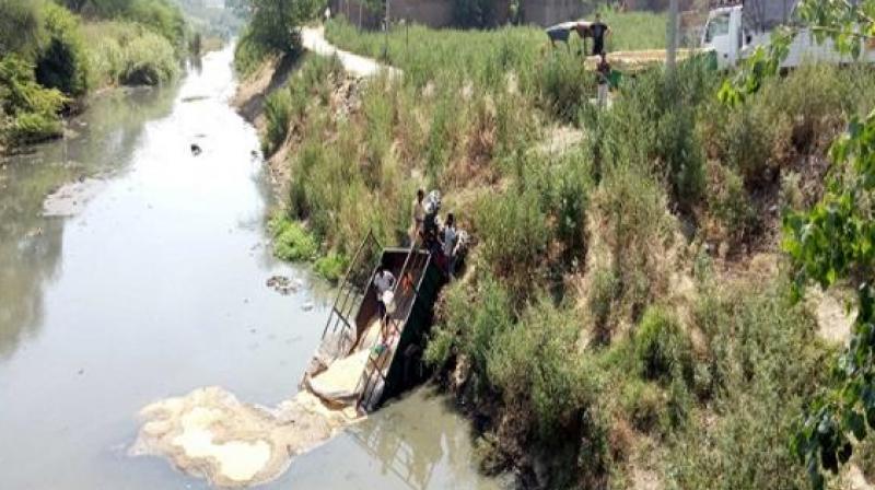 Tractor-trolley loaded with wheat fallen in Hansoli drain