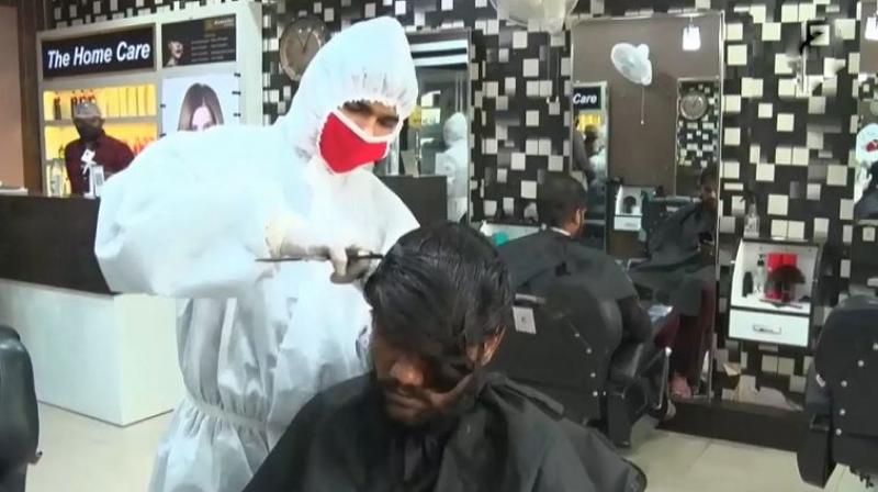 Covid 19 lockdown salon in gujarat workers wear ppe kits while giving haircuts 