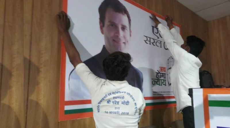 Worker putting Rahul Gandhi’s posters