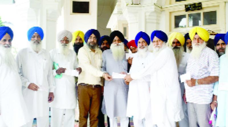 While giving a check to the religion soldiers, Manjit Singh Bapiana and others.