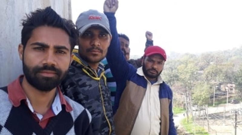 Powercom workers climb up on water tank 