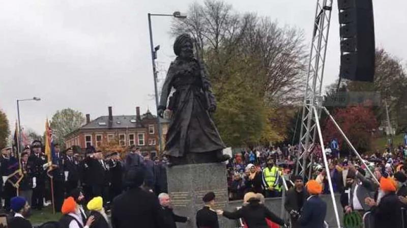 The statue stands on a granite plinth with inscriptions naming the regiments in which soldiers served.