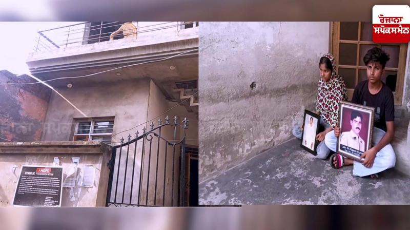 Brothers and sisters sit outside house with pictures of parents