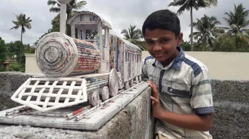 Boy creates train model using newspaper 