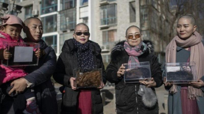 Wife of detained China activist goes bald for justice