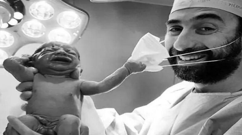Newborn baby pulls doctor's mask