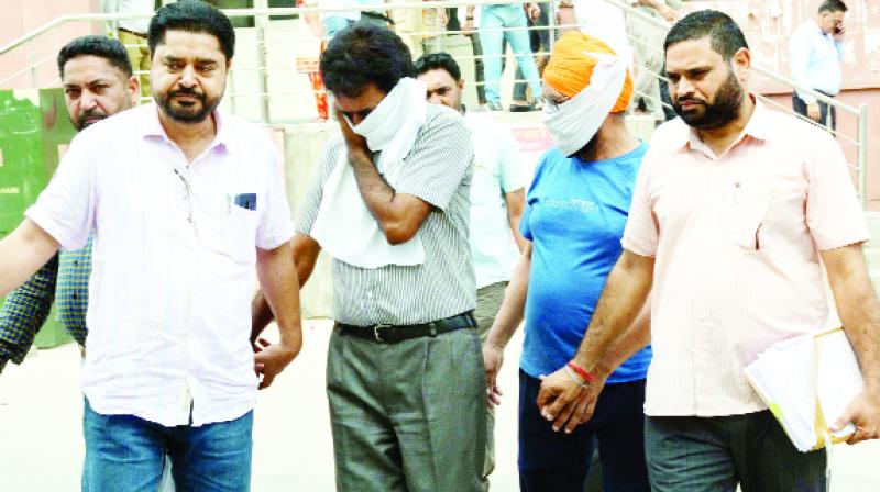 The Vigilance officials carry the accused for a hearing.  