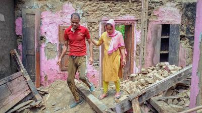Bhaderwah: 7-month pregnant Nishu walks through the rubble of her mud house, in Bhaderwah. (PTI Photo)