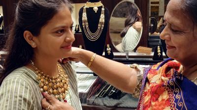 Patiala: A woman tries jewellery on Dhanteras, in Patiala, Friday, Nov. 10, 2023. (PTI Photo) 