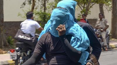 Amritsar: Commuters with their faces covered with a scarf ride past on hot summer day, in Amritsar, Saturday, May 18, 2024. (PTI Photo)