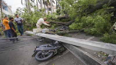 Jammu: Fallen electric poles on motorbikes due to gusty winds, in Jammu. (PTI Photo)