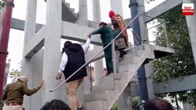 ਪੁਲਿਸ ਮੁਲਾਜ਼ਮ ਮਹਿਲਾ ਨੂੰ ਟੈਂਕੀ ਤੋਂ ਹੇਠਾਂ ਉਤਾਰਦੇ ਹੋਏ 