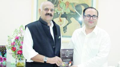 ReshmaJaswant Singh Puri, author of the book, handed over a book to V.P. Singh Badnore