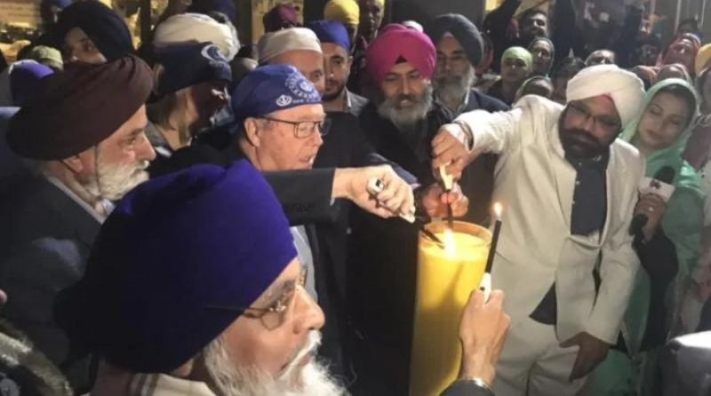Surrey Mayor Doug McCallum joins the ceremonial lighting of a candle that's set to burn for 550 hours to honour the 550th birthday of Guru Nanak