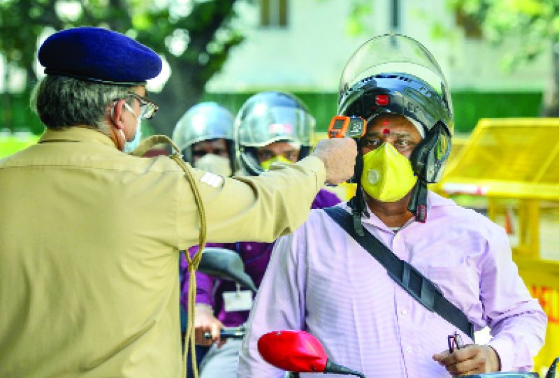 ਨਵੀਂ ਦਿੱਲੀ 'ਚ ਸਿਹਤ ਮੰਤਰਾਲੇ 'ਚ ਜਾਣ ਸਮੇਂ ਇਕ ਮੁਲਾਜ਼ਮ ਦੇ ਸਰੀਰ ਦਾ ਤਾਪਮਾਨ ਜਾਂਚ ਕਰਦਾ ਇਕ ਪੁਲਿਸ ਮੁਲਾਜ਼ਮ।