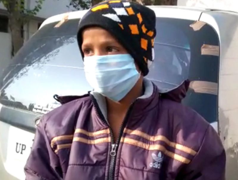 Homeless Boy sleeping on a footpath with a dog