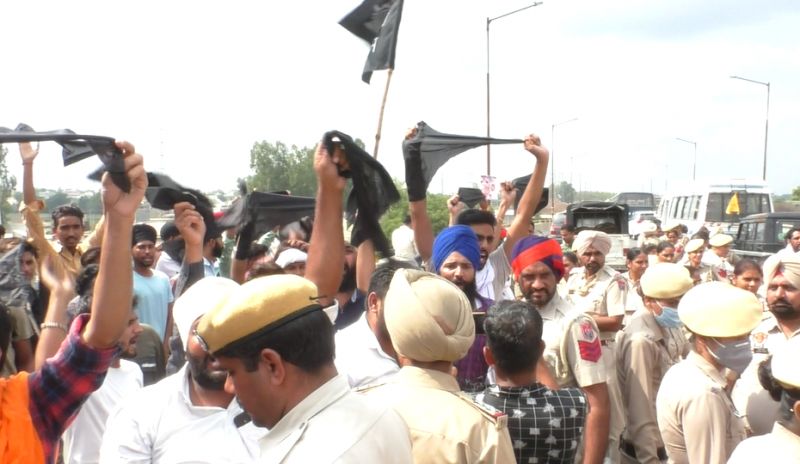 People raise black flags and slogans against Sukhbir Badal