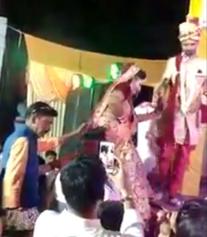 The bride climbed on the stage, fired, then grabbed the groom's hand