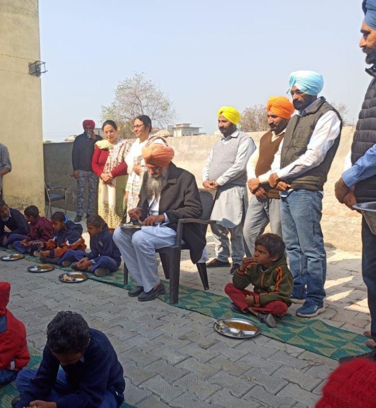 Speaker Sandhwan along with elementary students tastes mid-day meal